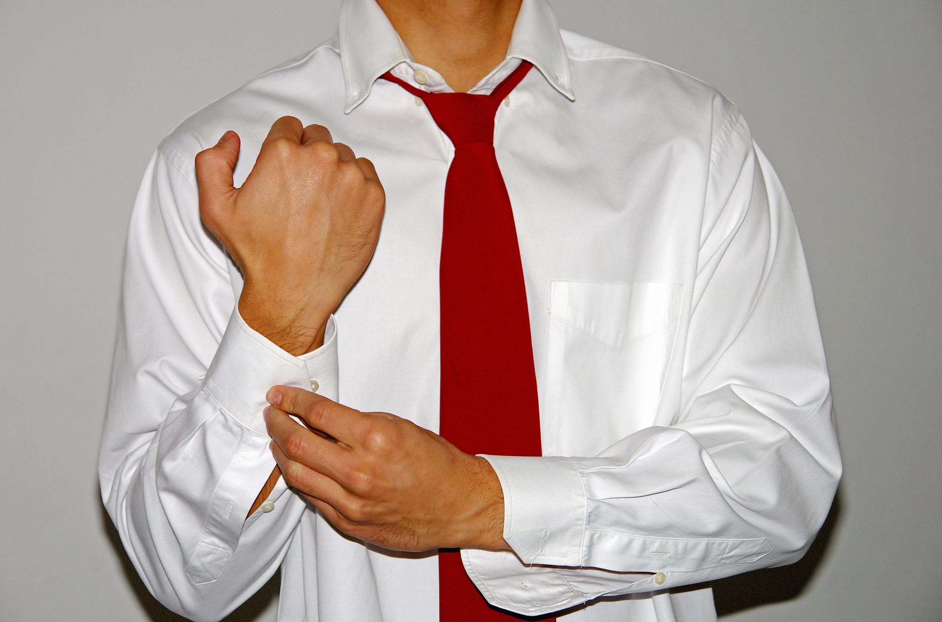 man doing up dress shirt cuffs